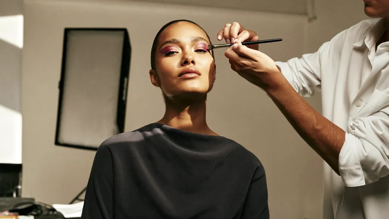 Farverig øjenskygge og grafisk eyeliner færdiggøres under studielys